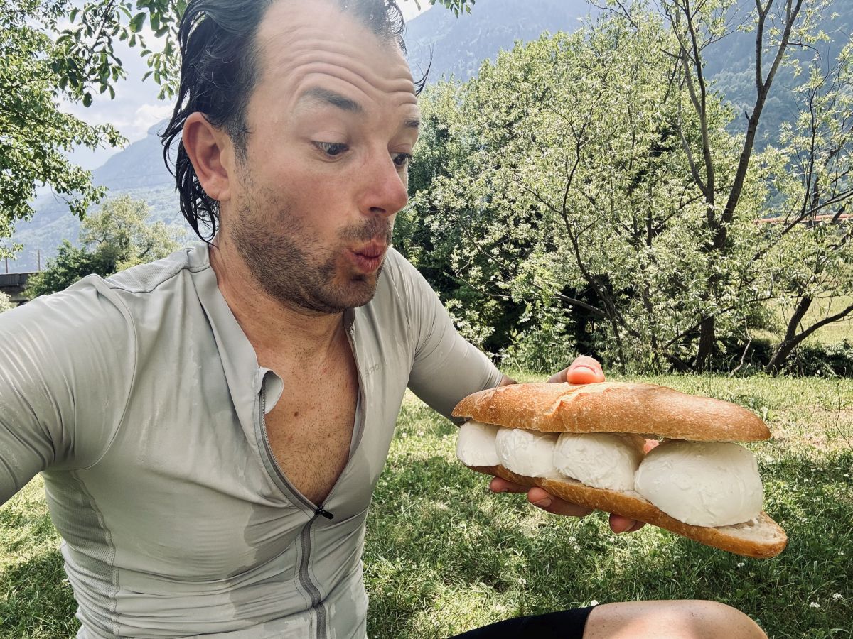 Malte Hempel mit Mozarellebaquette im Schatten eines Baumen bei seiner Transalp von Basel nach Mailand