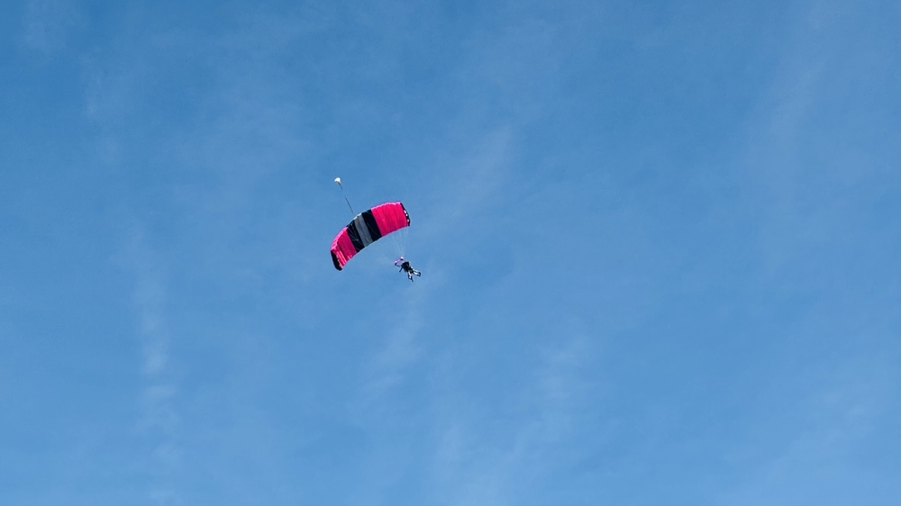 Malte beim Tandem-Fallschirmsprung vor dem blauen Himmel